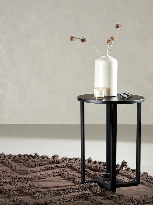 Bout de canapé rond noir sur fond blanc