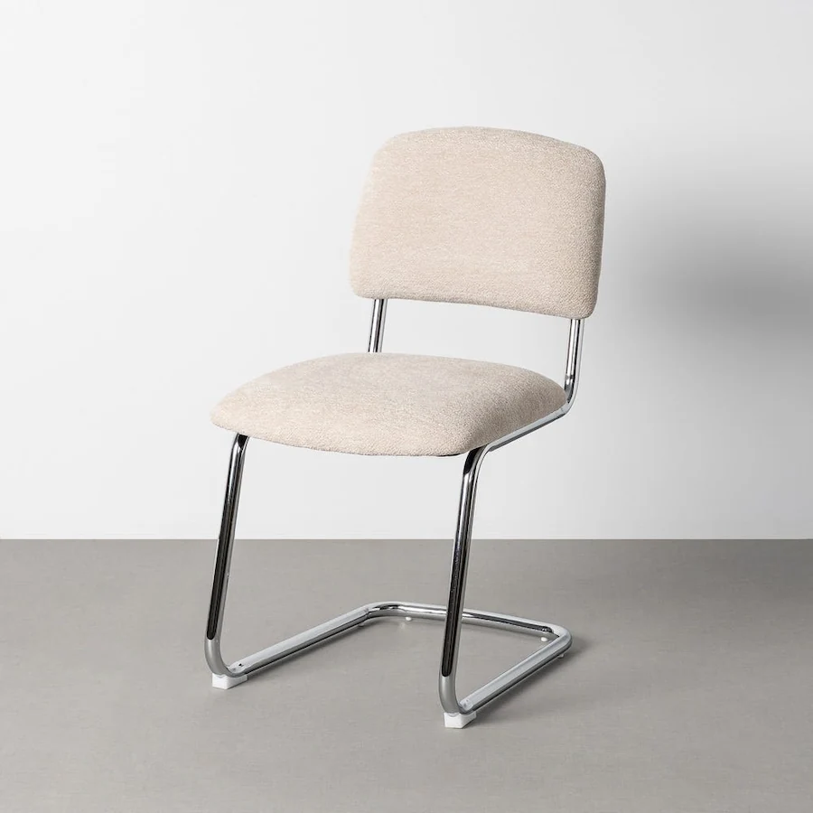 Chaise beige à piètement luge chromé, vue de trois quarts