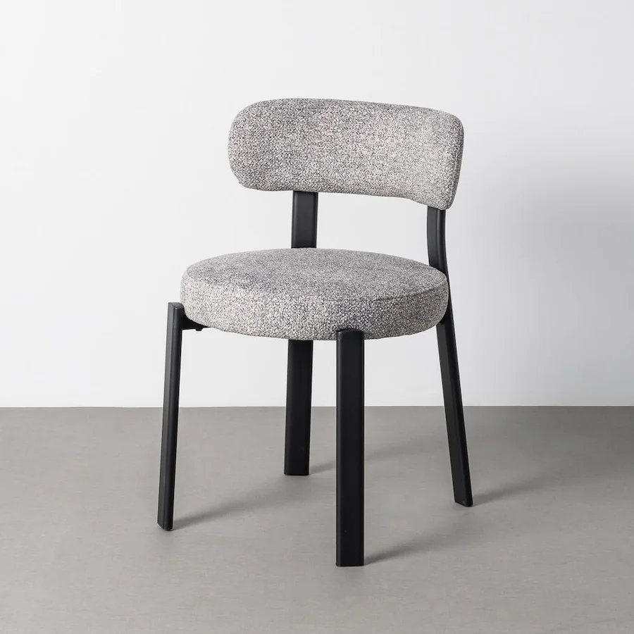Chaise tapissée gris chiné sur fond gris, vue de trois quarts