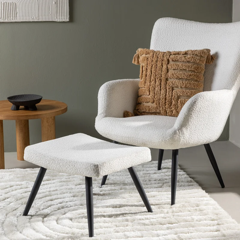 Fauteuil bouclette blanc à pieds fins noirs, vue de face avec repose-pieds