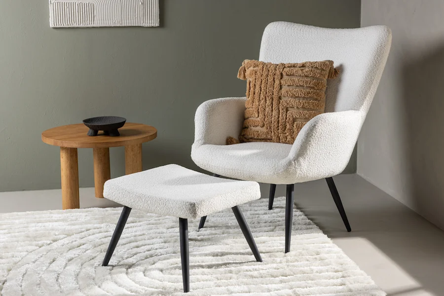 Fauteuil bouclette blanc à pieds fins noirs, vue de face avec repose-pieds