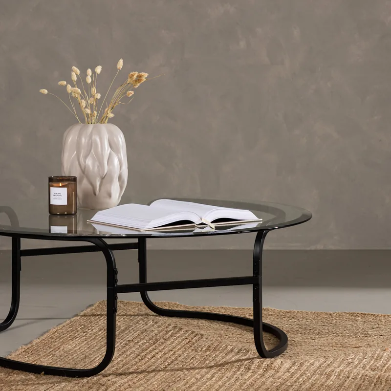 Table basse ronde Lomma, plateau en verre sur piètement en tube noir en boucles, vue de face
