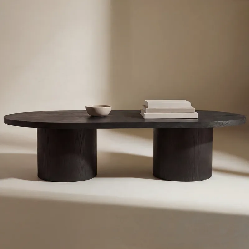 Table basse Narvik noire, plateau ovale allongé sur deux pieds cylindriques, vue de face