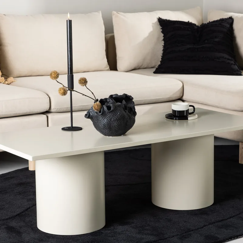 Table basse Sandvika beige brillant sur deux pieds cylindriques, vue de face
