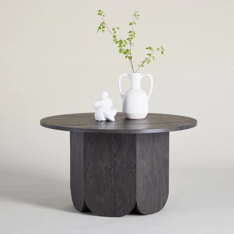 Table basse ronde Tekla noire, vue de face : plateau de 80 cm sur un pied de panneaux en arche