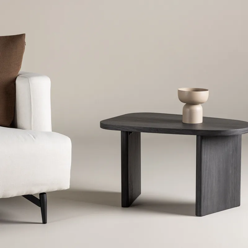 Table d'appoint Grönvik noire, plateau aux bords galbés sur pieds en panneaux pleins, vue de trois quarts