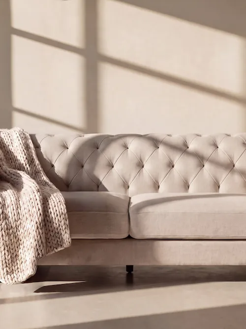 Canapé Chesterfield pieds noirs Velvet beige vu de face, dossier capitonné