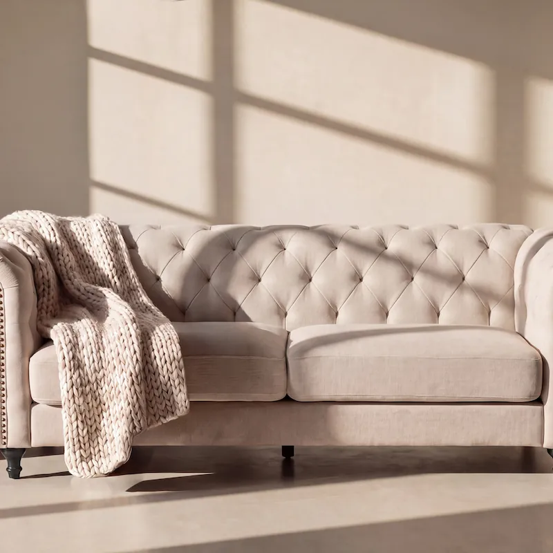 Canapé Chesterfield pieds noirs Velvet beige vu de face, dossier capitonné