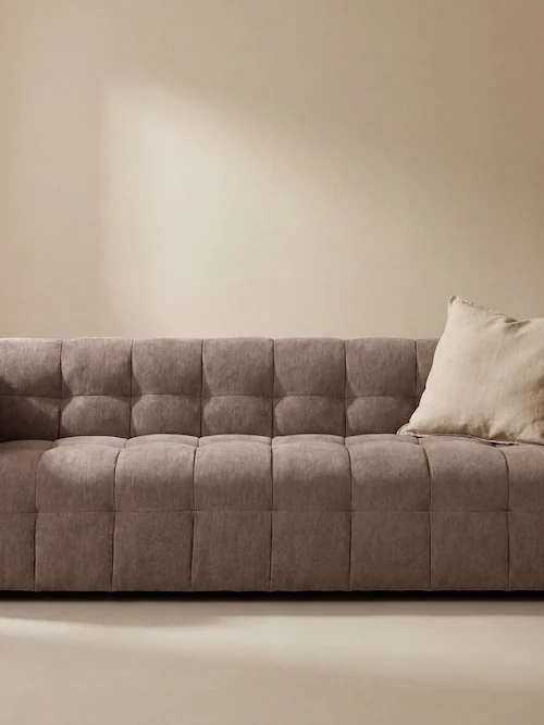 Canapé taupe en trois quarts avant, accoudoirs bas et assise matelassée