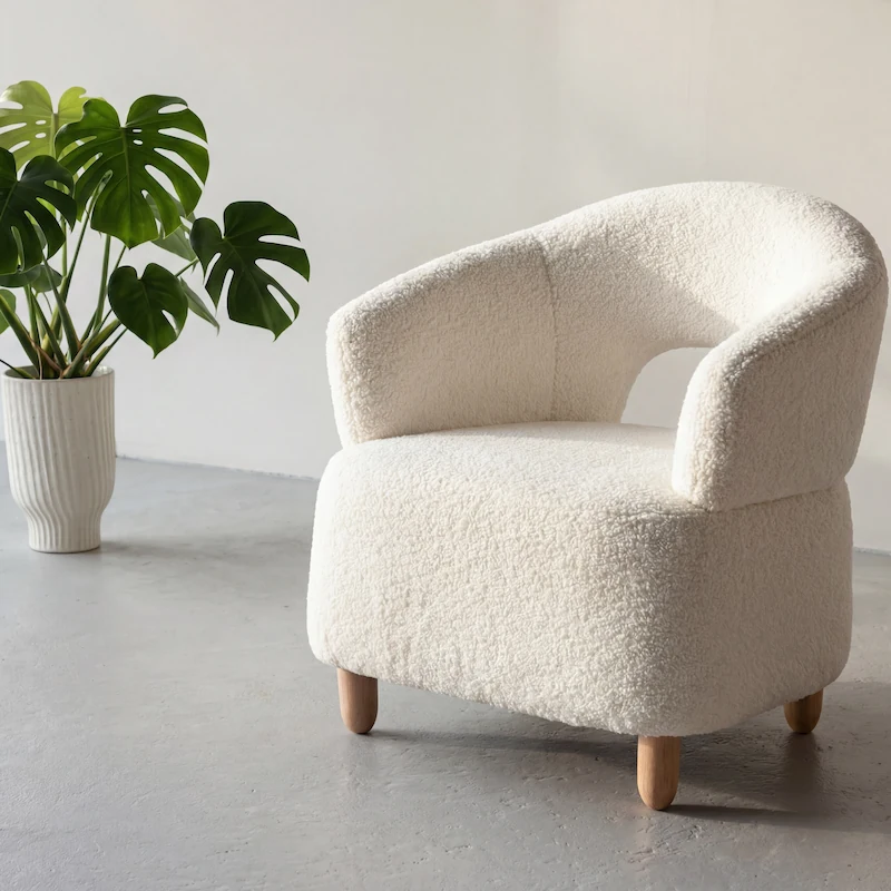 Fauteuil Moglas en bouclé blanc vu de face, avec son dossier arrondi ajouré et ses pieds en bois clair