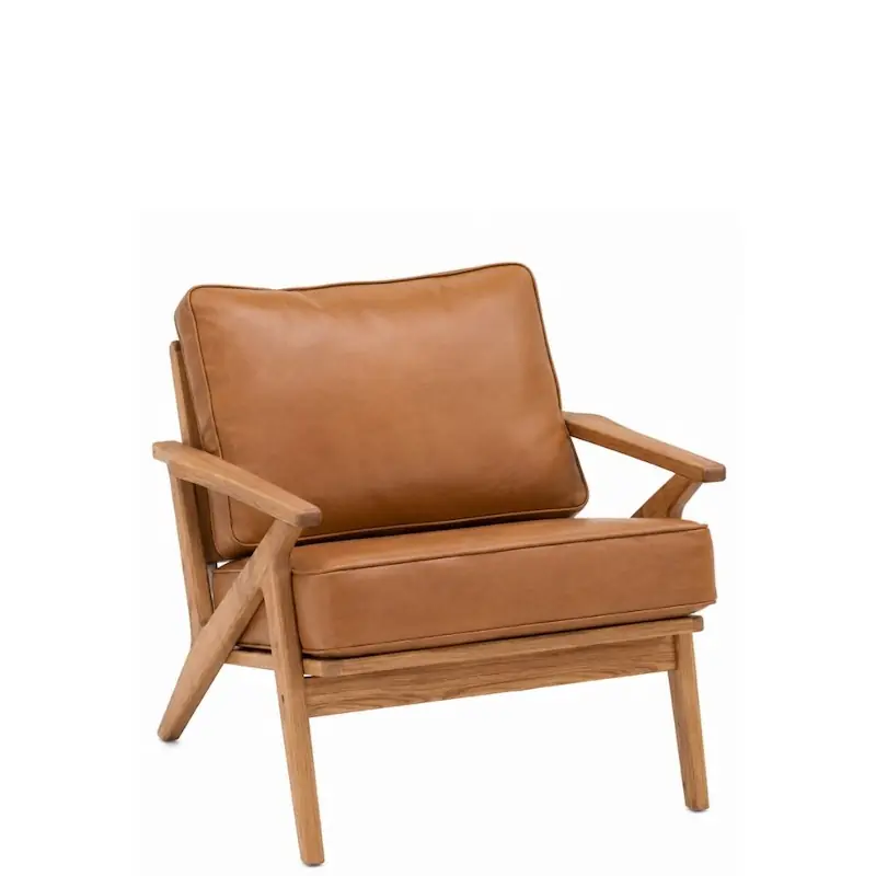 Fauteuil Adam en chêne et simili cuir camel, montants croisés et coussins à passepoil, vu de trois quarts