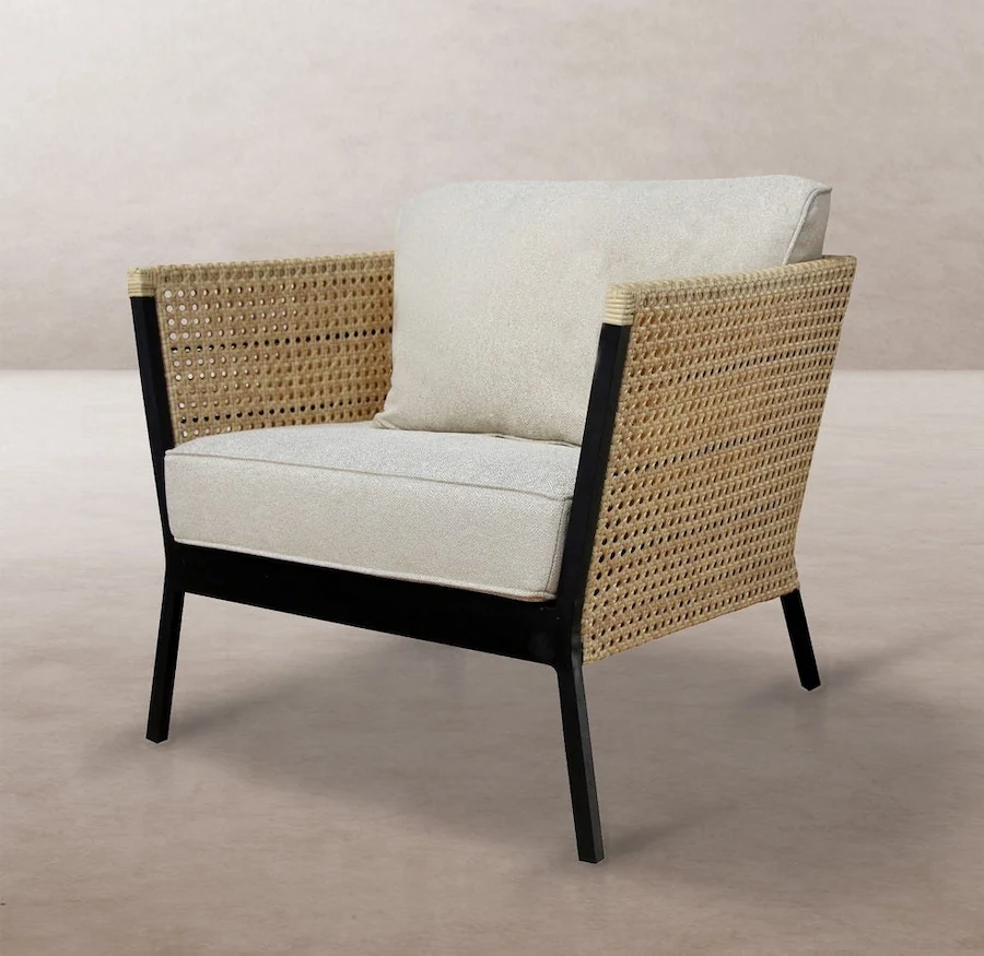 Fauteuil de jardin en aluminium noir, flancs tressés ajourés, coussins crème d'assise et de dossier, trois quarts