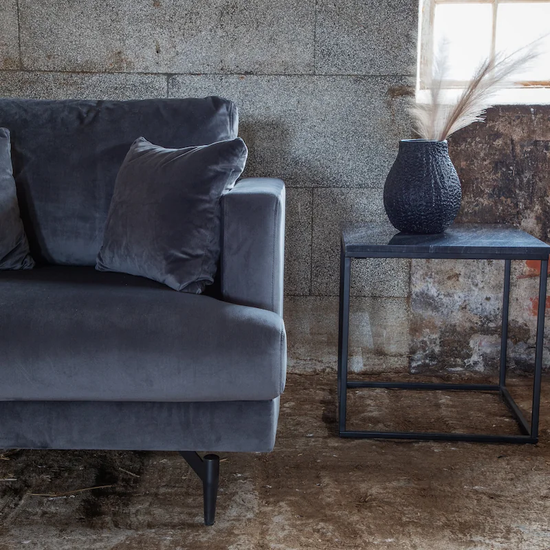 Fauteuil Sofia gris foncé en velours, vu de face avec deux coussins décoratifs