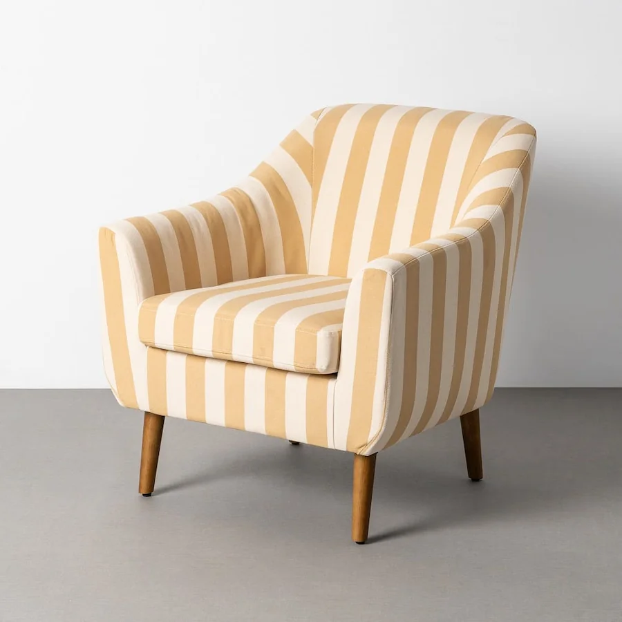 Fauteuil rayé miel et écru à accoudoirs arrondis et pieds en bois, vu de trois quarts
