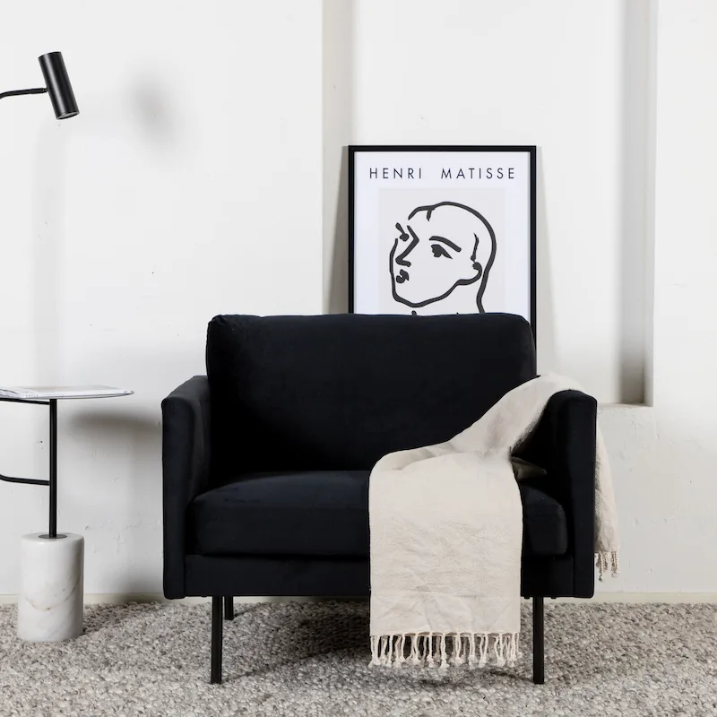 Fauteuil Zoom en velours noir vu de face, sur pieds fins en métal noir