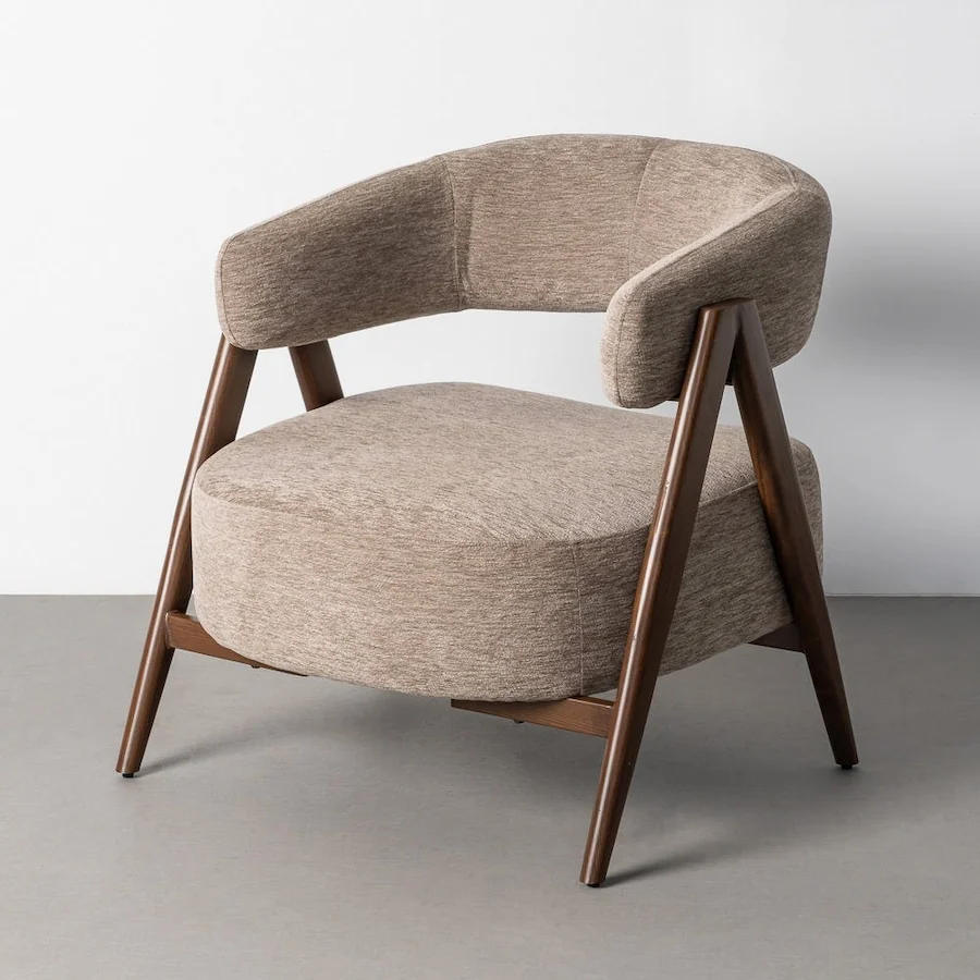 Fauteuil en tissu taupe Ixia, dossier arrondi et pieds inclinés bruns, vu de trois quarts