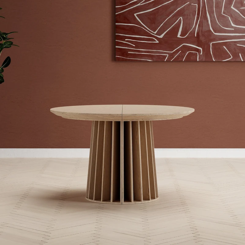 Table ronde au plateau clair posée sur un pied cannelé, vue de face sur fond blanc