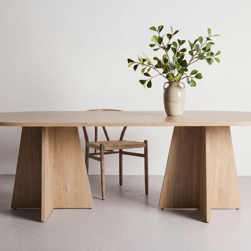 Table à manger ovale Bootcut à plateau fin, vue de face, deux pieds en croix
