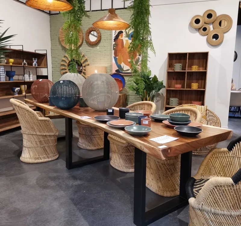 Table à manger Suar à bords naturels sur piètement en fer noir, dressée avec des fauteuils