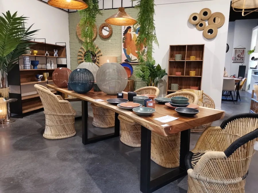 Table à manger Suar à bords naturels sur piètement en fer noir, dressée avec des fauteuils