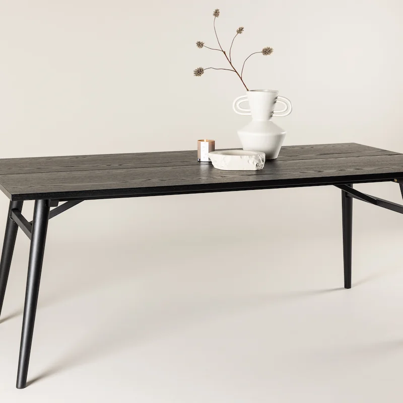 Table à manger acier noir Venture Home vue de face, pieds évasés en métal reliés par des traverses inclinées