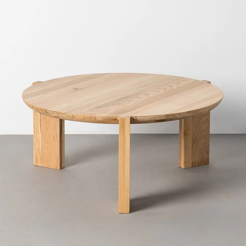 Table basse ronde en chêne clair Ixia, grand plateau au veinage visible sur trois larges pieds en bois