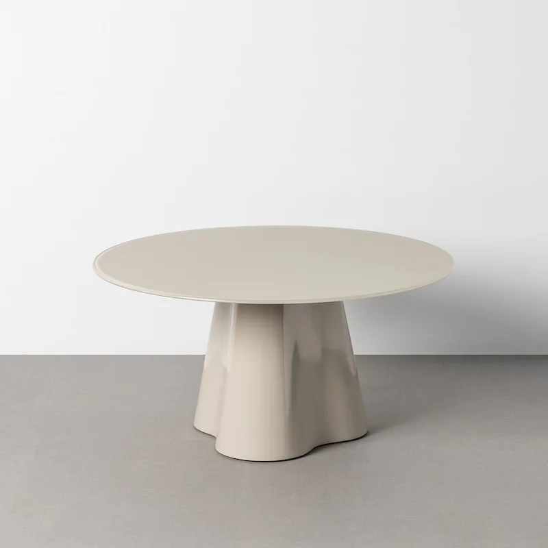 Table basse ronde crème Ixia, plateau en verre sur pied central évasé, vue de trois quarts