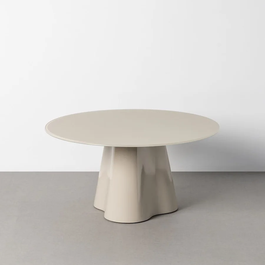 Table basse ronde crème Ixia, plateau en verre sur pied central évasé, vue de trois quarts
