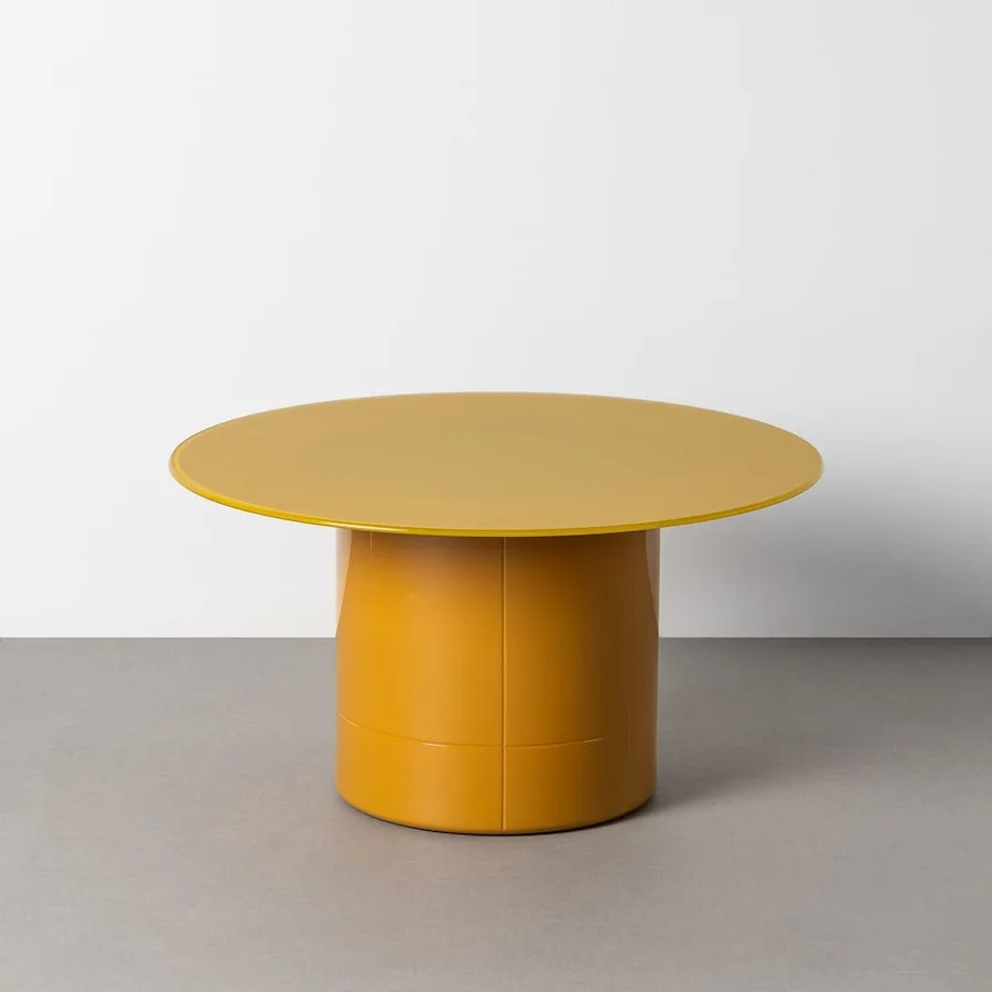 Table basse ronde Ixia, plateau en verre transparent sur pied central cylindrique jaune moutarde, vue de trois quarts